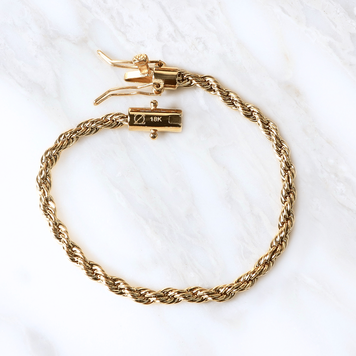 Pulsera Vortice Aureo  4mm en Oro laminado 18K. Su diseño se distingue por su trama sólida y continua, creando una silueta firme que proyecta presencia definida sobre la muñeca. Broche tubo para mayor firmeza.
Descúbrela en distintos tamaños y presentación.
Di Vogel Joyería Premium Chile