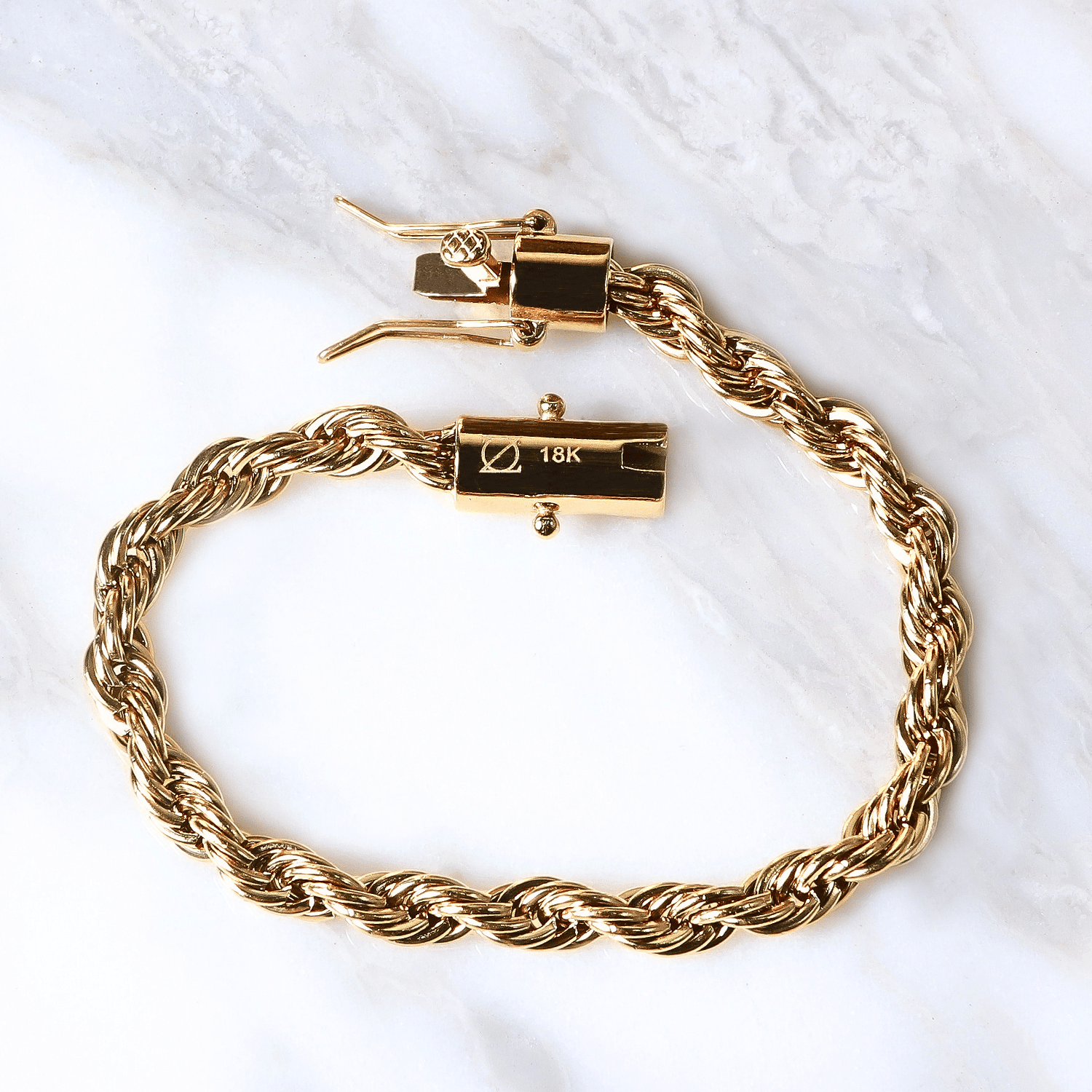Pulsera Vortice Aureo  6mm en Oro laminado 18K. Su diseño se distingue por su trama sólida y continua, creando una silueta firme que proyecta presencia definida sobre la muñeca. Broche tubo para mayor firmeza.
Descúbrela en distintos tamaños y presentación.
Di Vogel Joyería Premium Chile